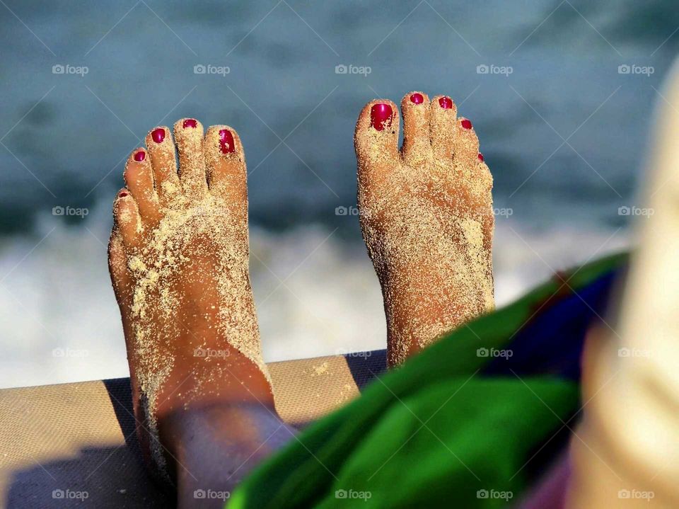 Sandy womans feet in sunlight