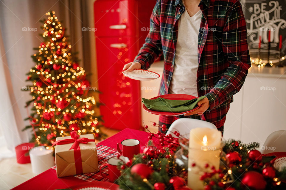 man sets a beautiful decorated winter table for a festive dinner.  Merry Christmas and Happy New Year.