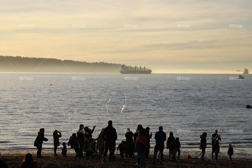 People on the beach playing with soapy bubbles