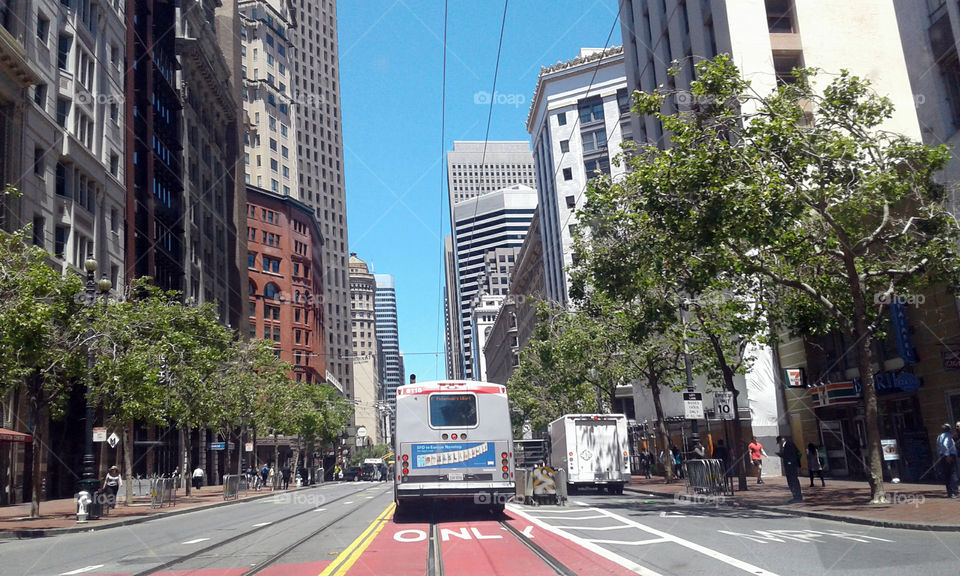 a somewhat stereotypical picture of downtown San Francisco with all of the tracks in this road for the trolleys that come through