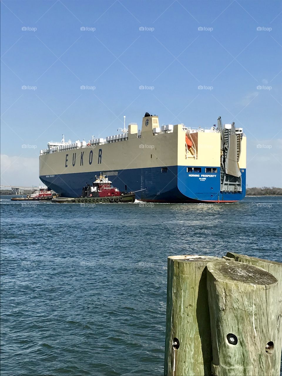 Tug boats bringing Car carrier ship into port in Charleston Harbor
