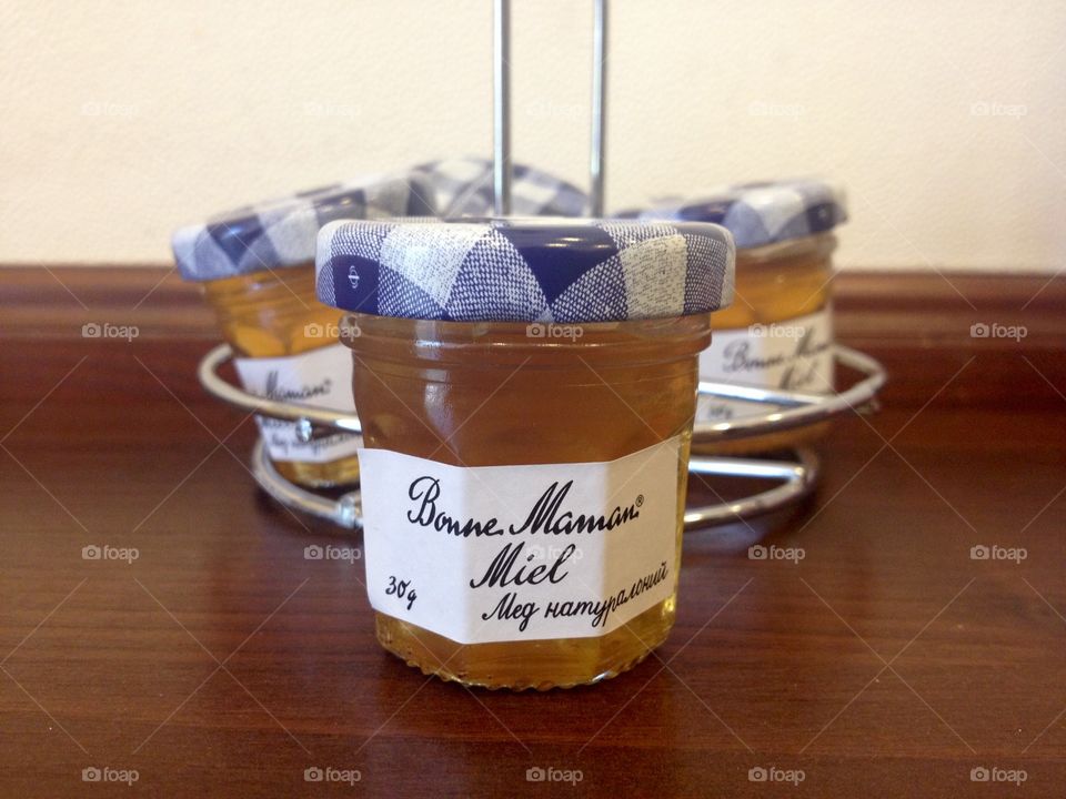 Little cans with honey on a wooden shelf