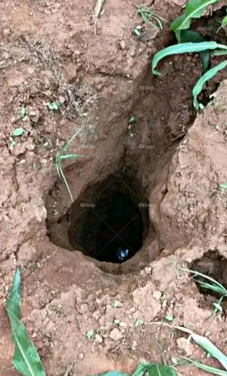 A scary deep hole inside the ground.