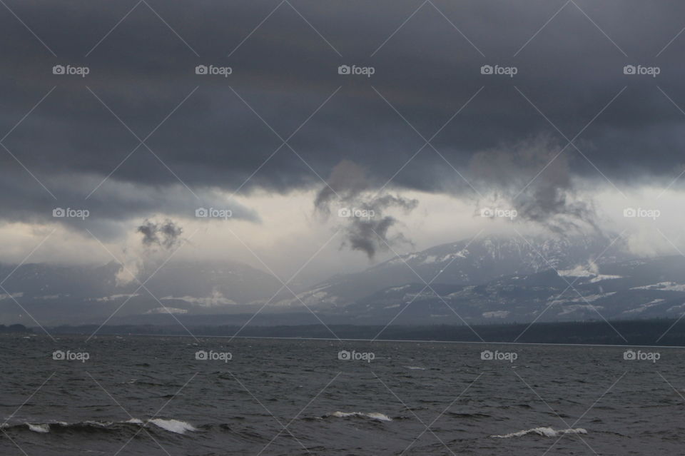 Some sunrise shots of the ocean on a windy Pacific Northwest morning. The mountains were misty and the sun was attempting to shine through but I could see clouds growing and darkening. Whitecaps were visible and the sea was dark blue.