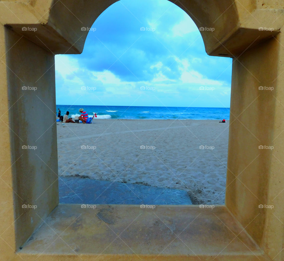 View of Hollywood Beach in Miami threw a concrete frame! The blue waters of Atlantic Ocean contrast with the blue clouds in the sky!