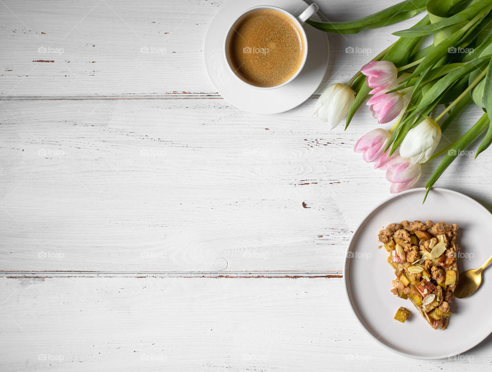 Girls cup of coffee with a piece of cake and flowers 