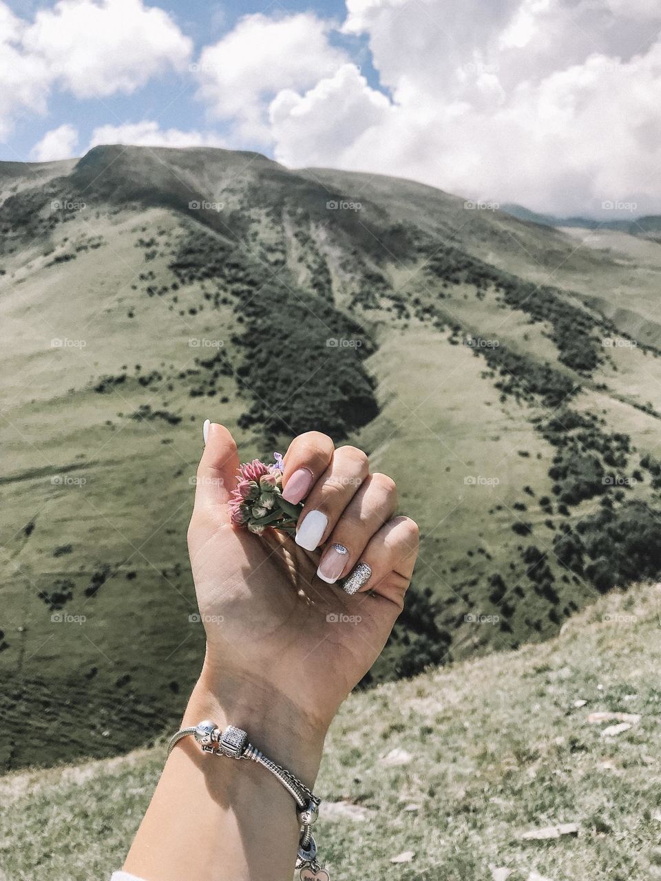 Woman manicure against natural mountain background. Female beautiful nails. 