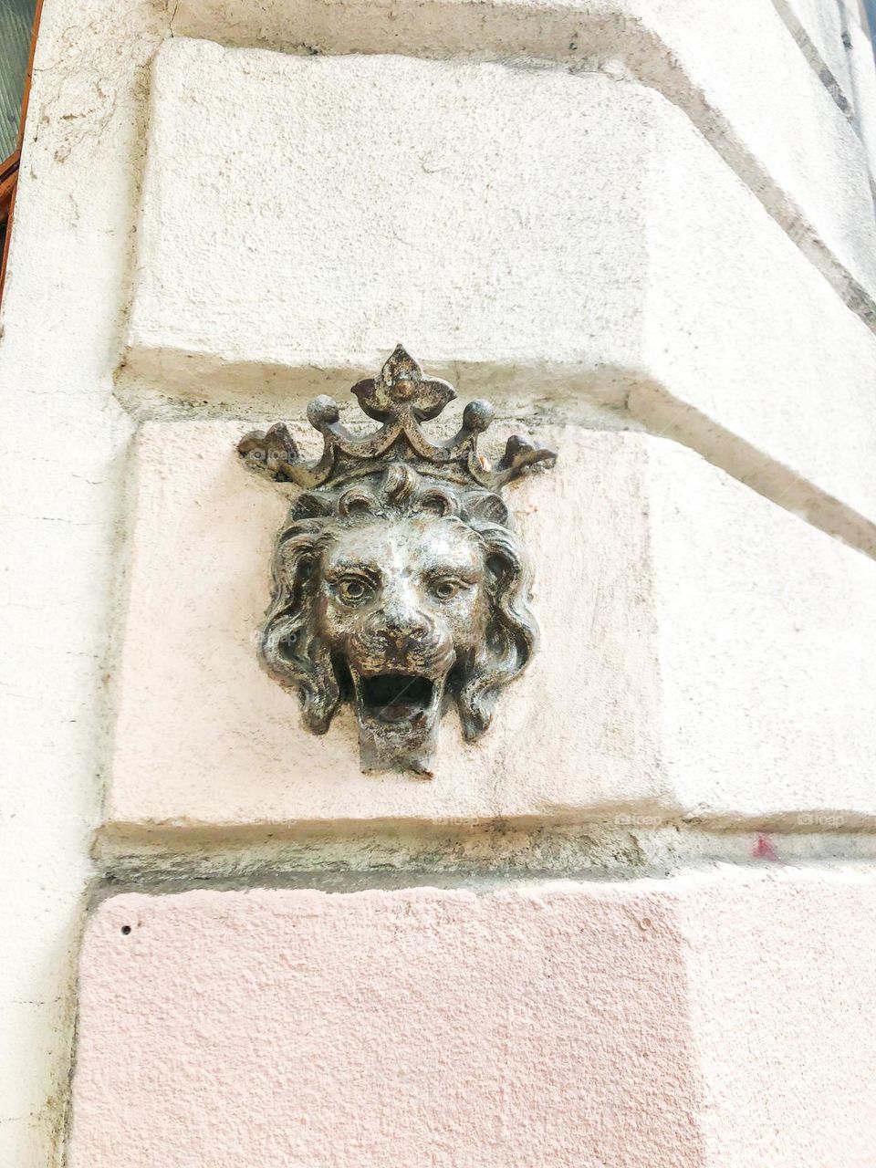 Metal sculpture of a lion with crown on an old building 