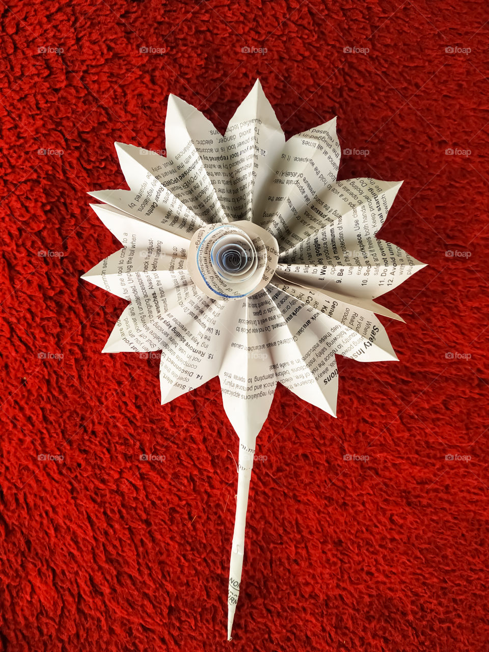 Sunflower flower made of white paper on a red background.