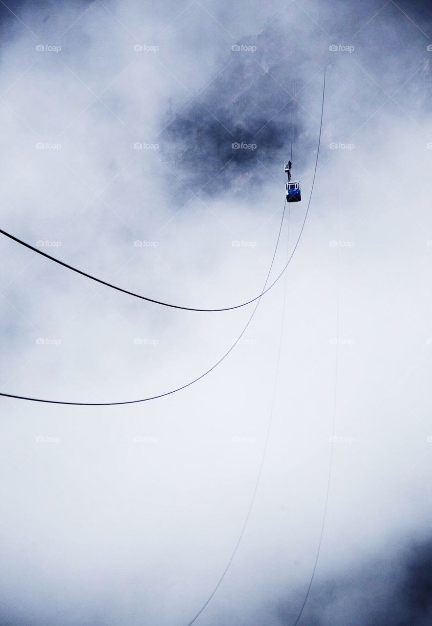 Gondola in the mist . High wire gondola 