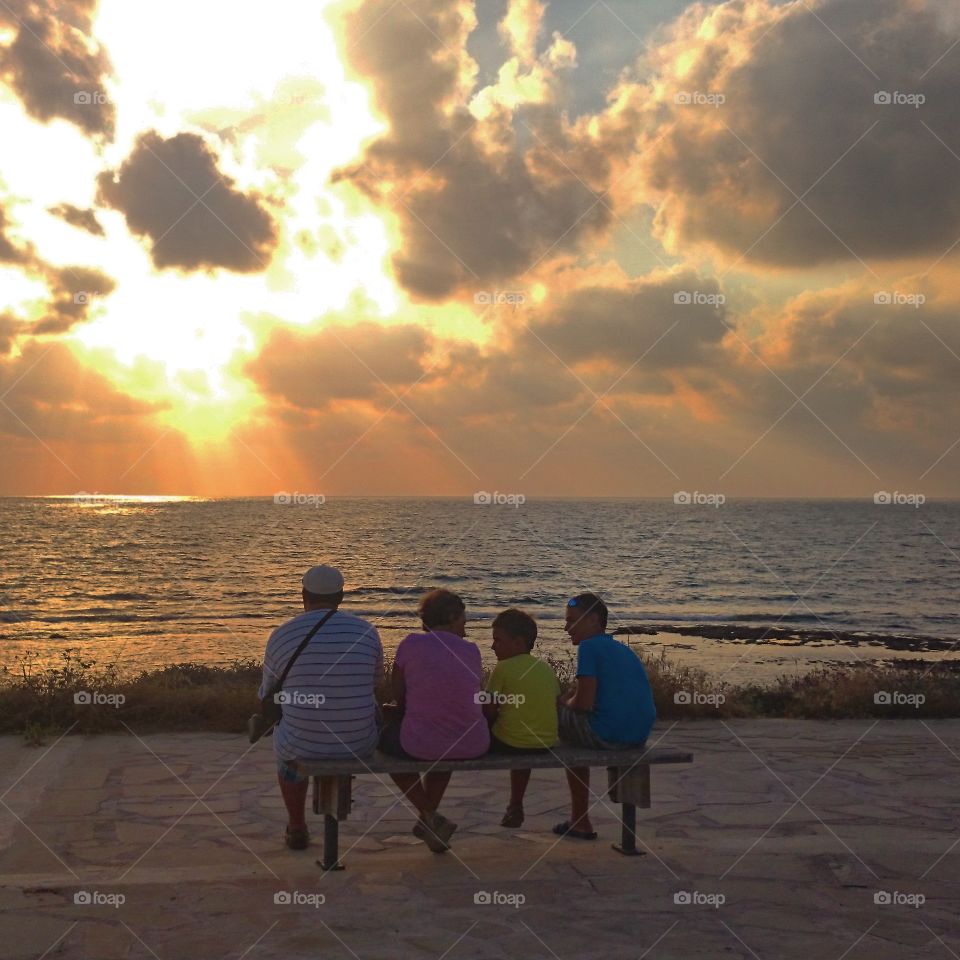 Family waiting for the sunset. As I walked towards the Lighthouse beach in Paphos, Cyprus