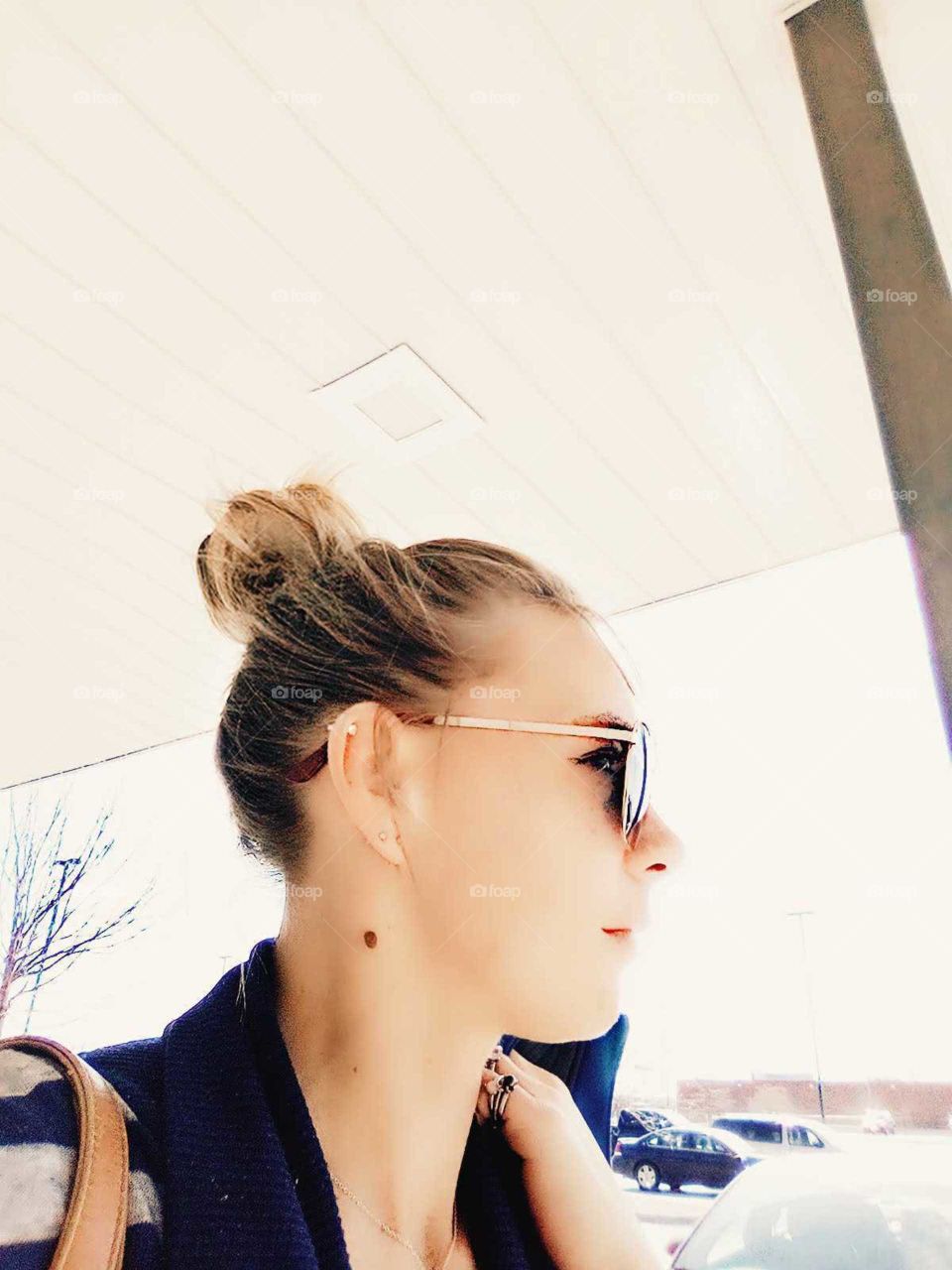 woman in a bun walking outside wearing sunglasses