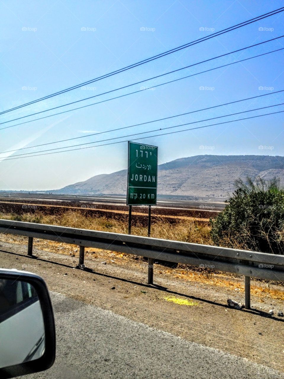 sign in Israel to get to Jordan in kilometers with mountain background