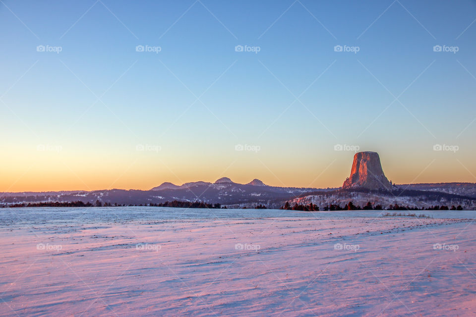 Colorful, snowy sunset at Devils Tower. 