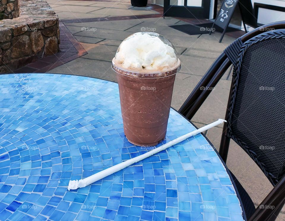 refreshing cold drink with whipped cream on a blue tiled table at a Cafe in California