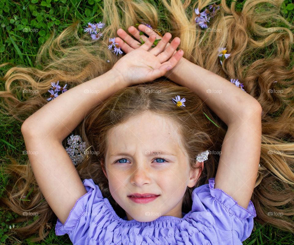 portrait of a spring girl, dressed in purple and purple spring flowers in her hair