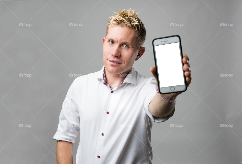 Happy man with cellular phone smiling and showing his phone.