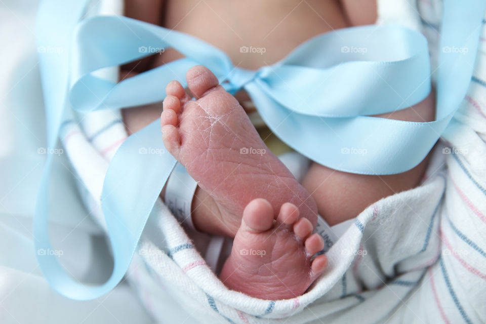 A close up detail shot of a newborn baby boy’s feet 