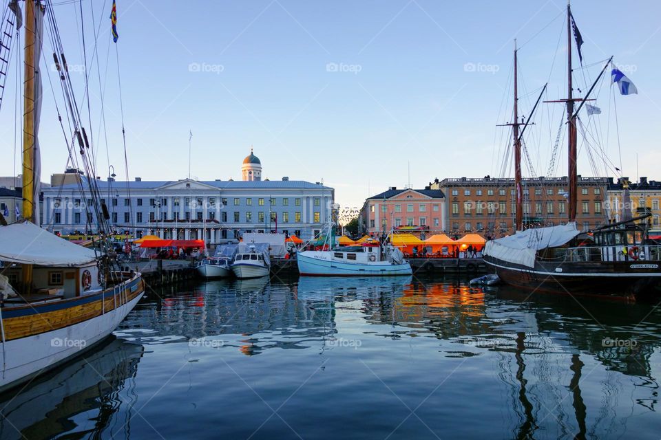 Helsinki, Finland - October 7, 2015: Fishing boats and an old sailing boat at the Helsinki Market Square (Kauppatori in Finnish) with market tents on the background during the annual Helsinki Baltic Herring Fair (Silakkamarkkinat in Finnish).