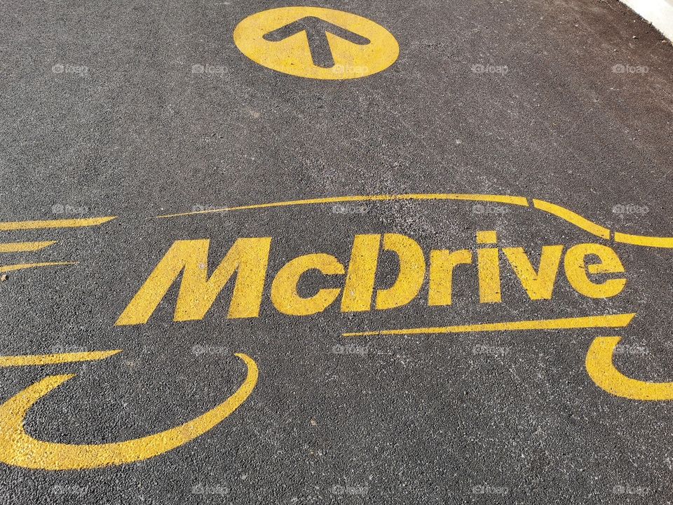 Mcdrive written on the asphalt near a Mc Donald's