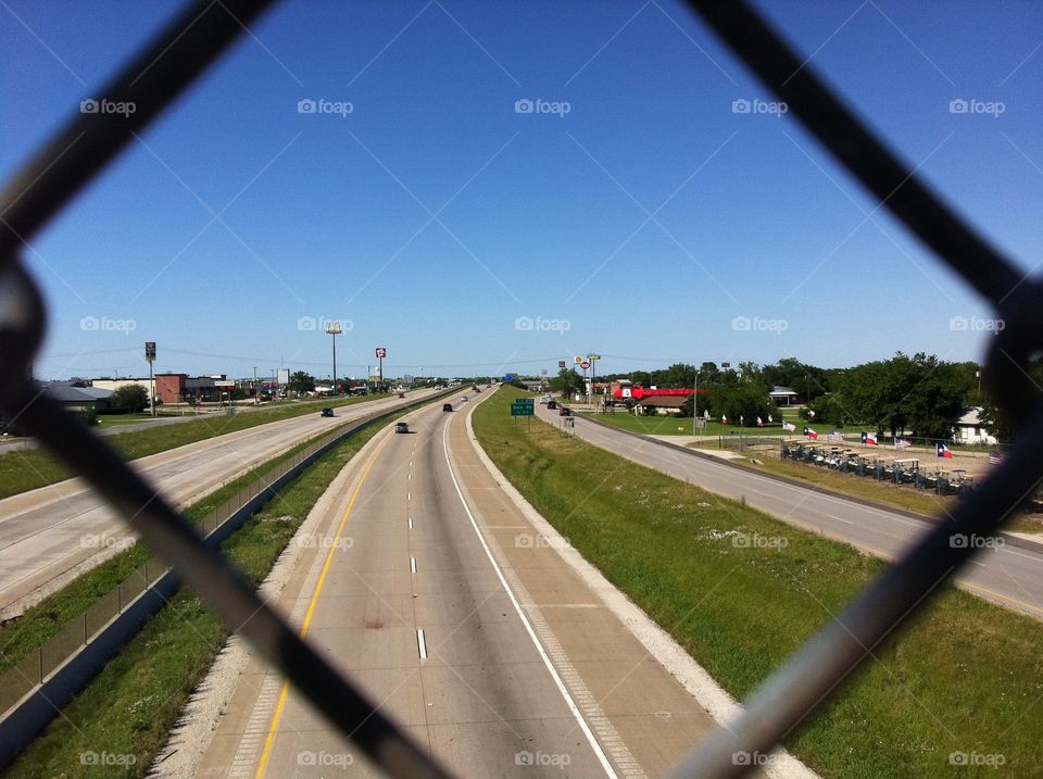 Texas highway from behind fence. 