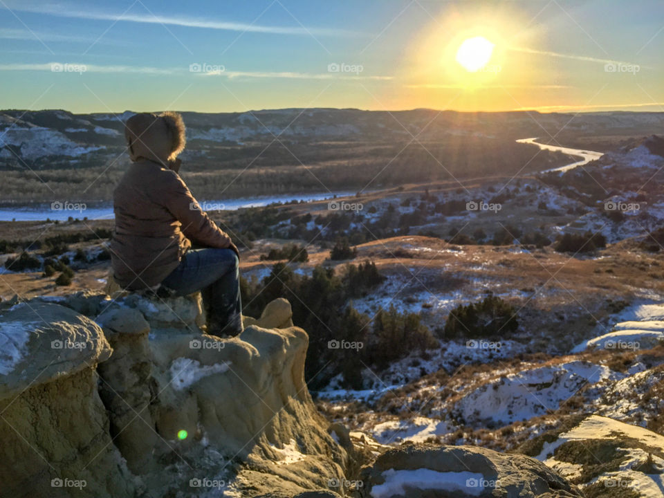 Looking out over a frozen river valley at sunset in the North Dakota badlands at Theodore Roosevelt National Park.