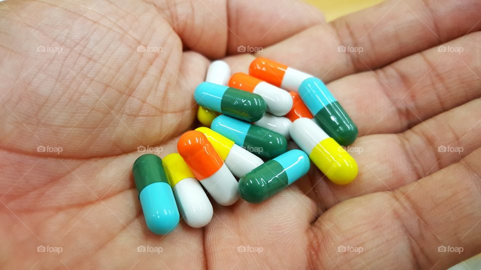 colorful medicine capsules in hand