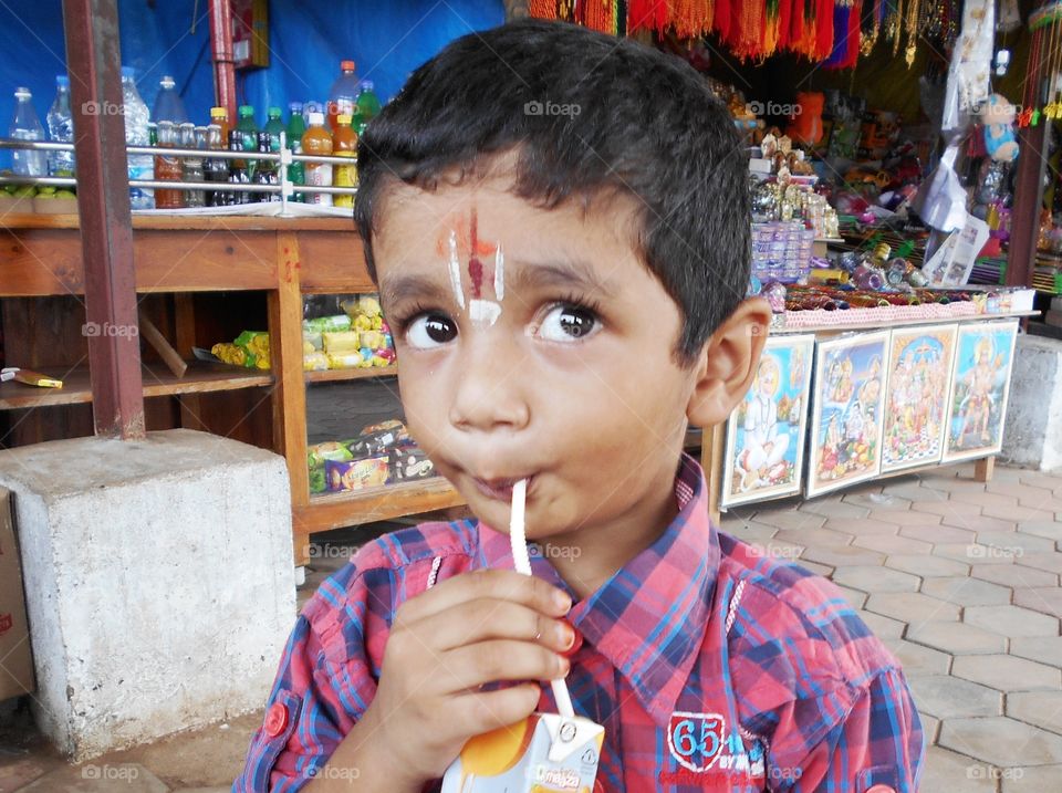 Close-up of a boy drinking juice with straw