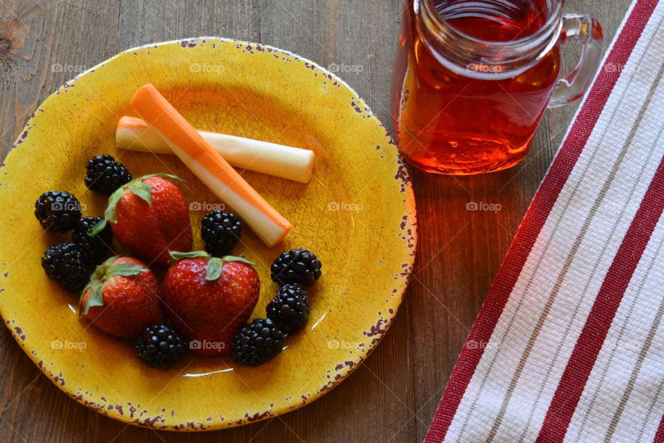 Cheese sticks and fruit with a glass of juice