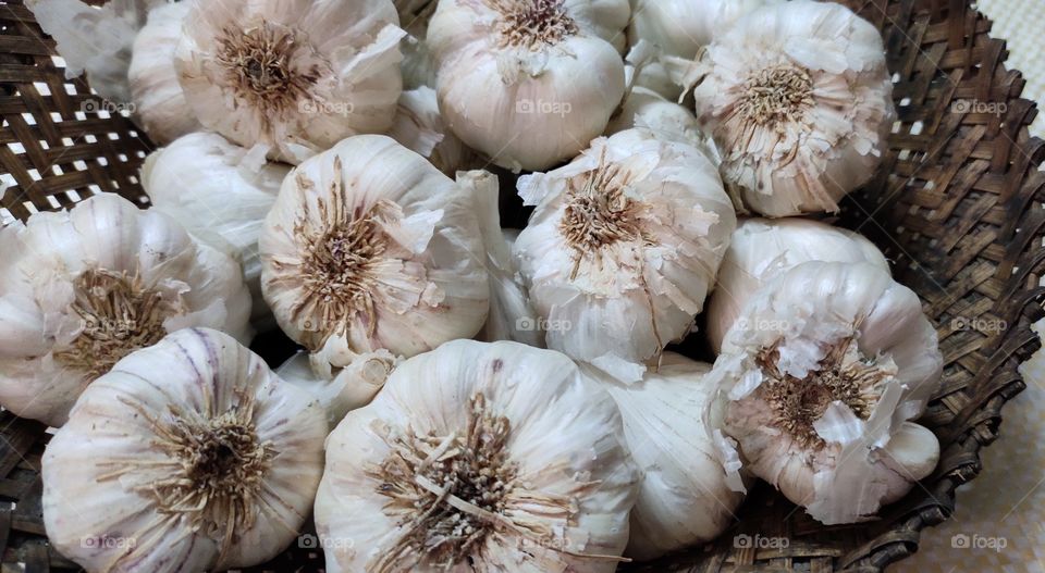 bunch of garlic in a wooden weaved basket