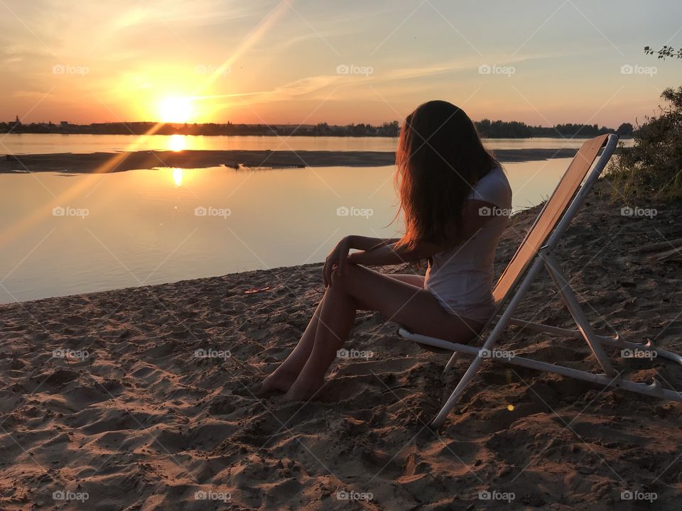 Girl at sunset by the river.