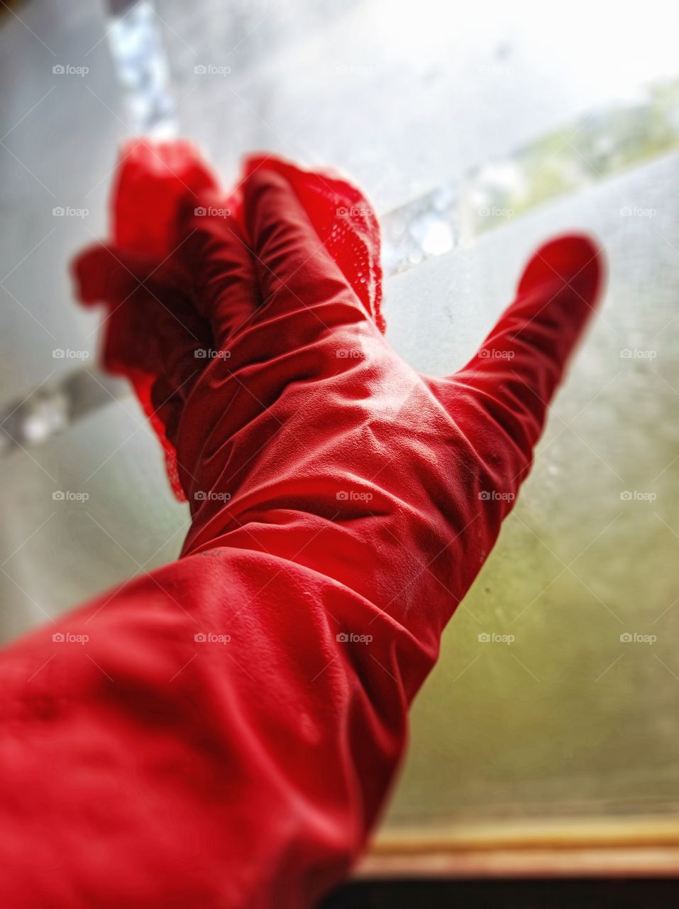 Window cleaning with red rubber gloves