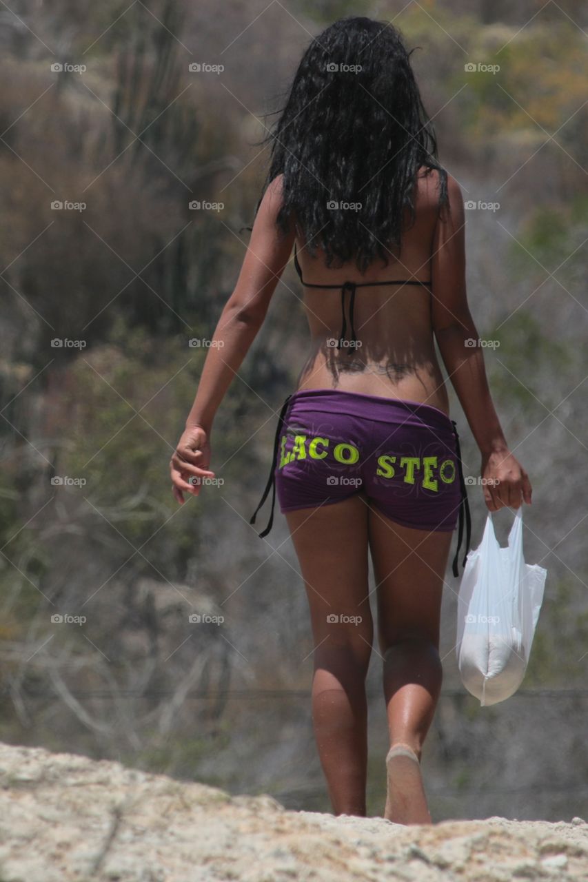 Girl walking along sandstone cliffs.Guantanamo.Cuba