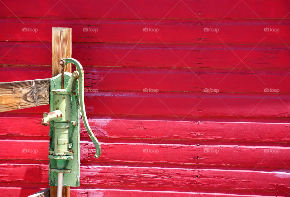 Old water pump against red background