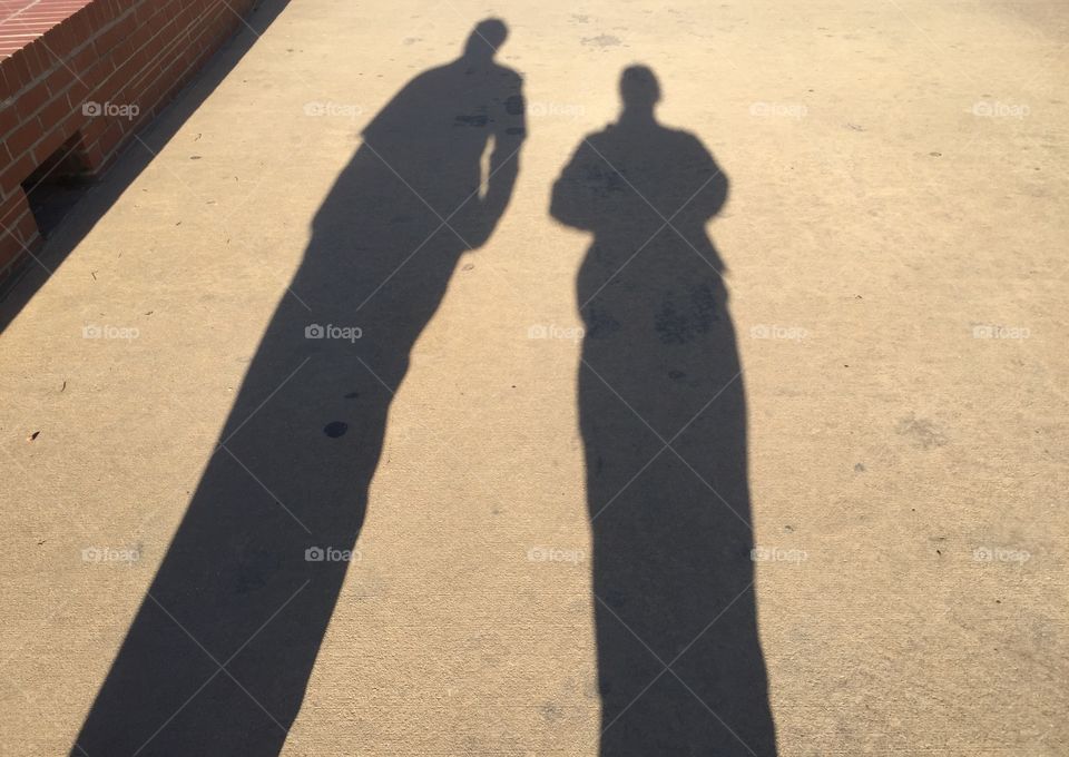The shadows of a man and woman walking
