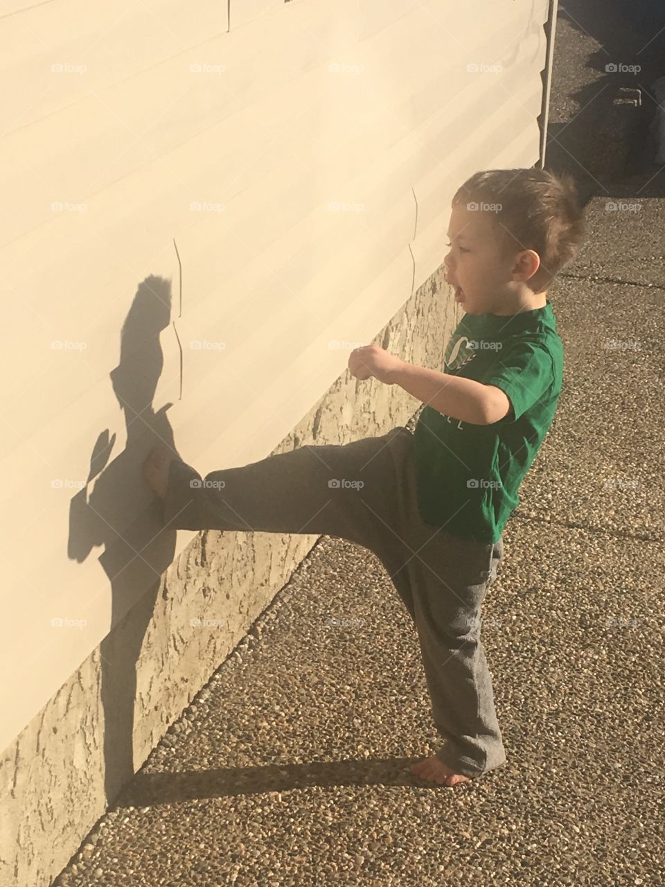 Practicing karate against his shadow 