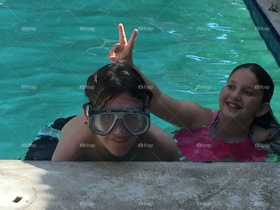 Siblings having fun in the pool