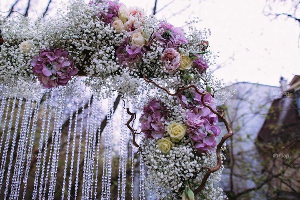 A part of a wedding flower arch. A refined floral composition with cascading strands of glass beads. Perfect as a background 