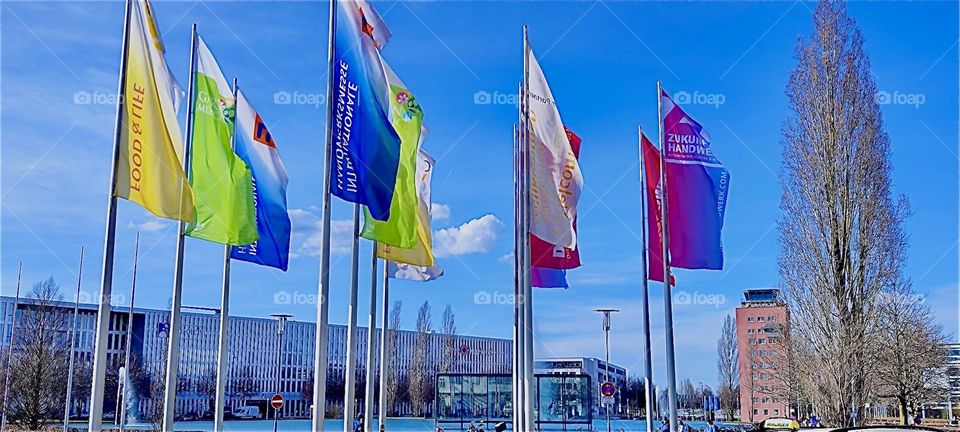 These colorful flags invite to partake in one of several trade shows at the convention center in “München” or “Munich” in March 2024. Hypnotic Productions
