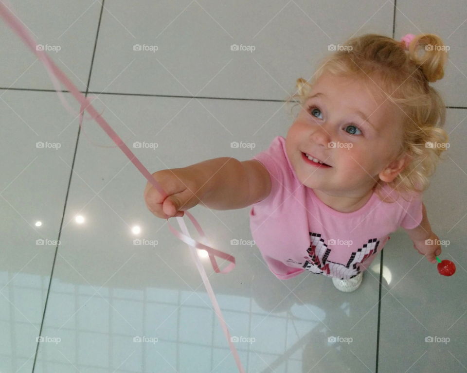 Happiness. cute happy little girl and pink ballon