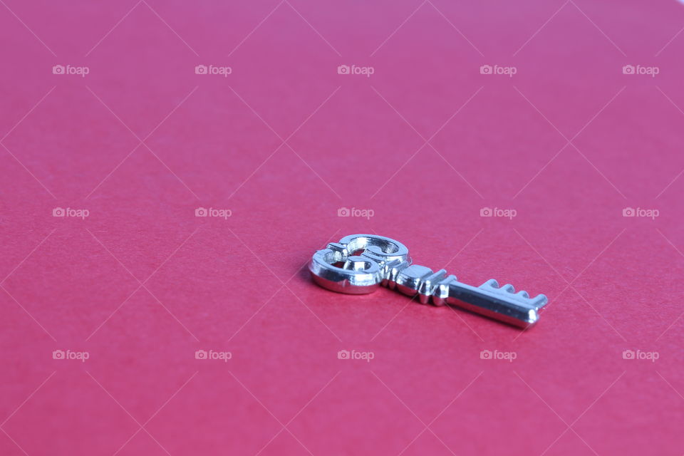 iron miniature key on pink background