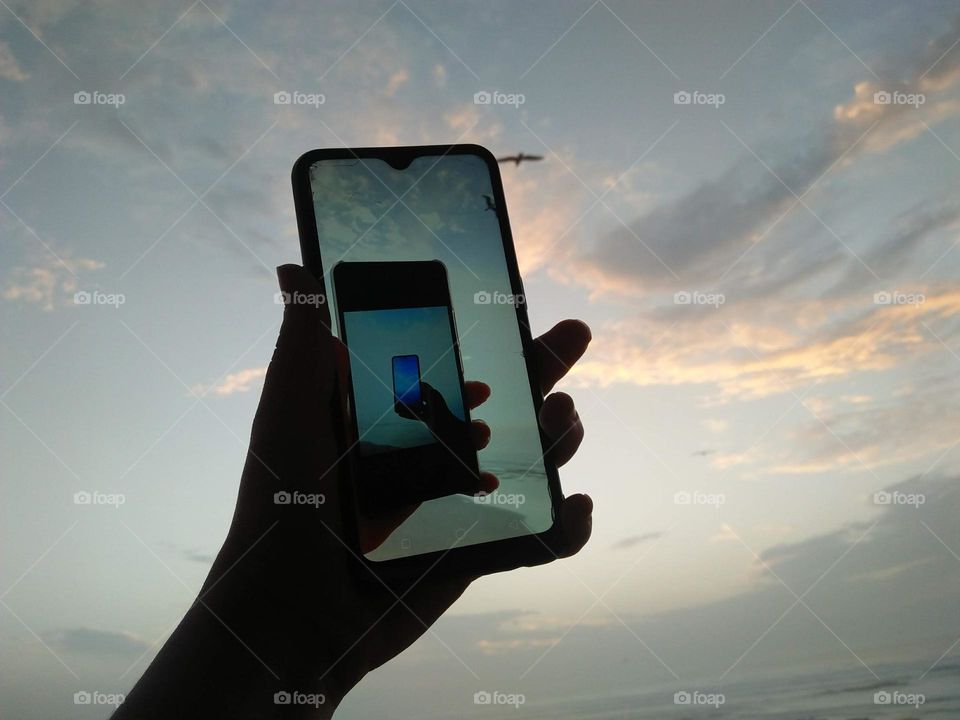 a human hand holding smartphone to catching videos