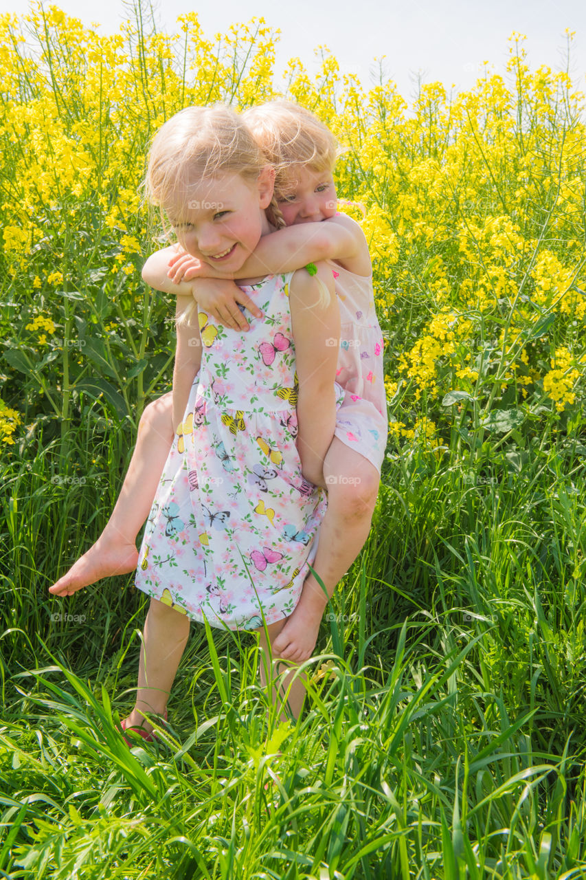 Smiling sisters playing in field