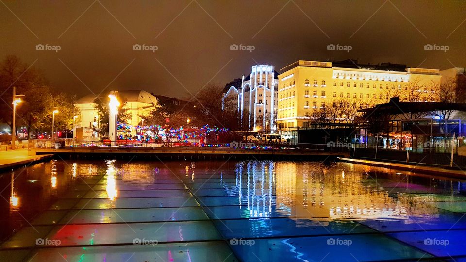 Xstmas market in Budapest city center, full of color and lights...... acvquarium club of Budapest is visible under the water