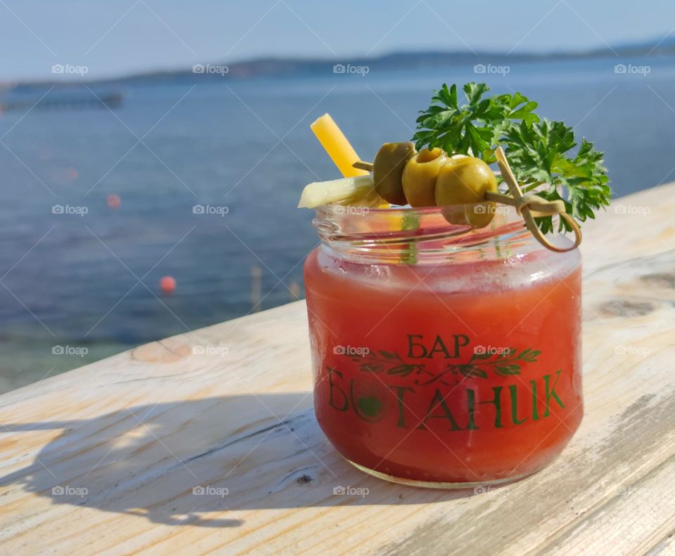 Delicious red and juicy cocktail on the beach