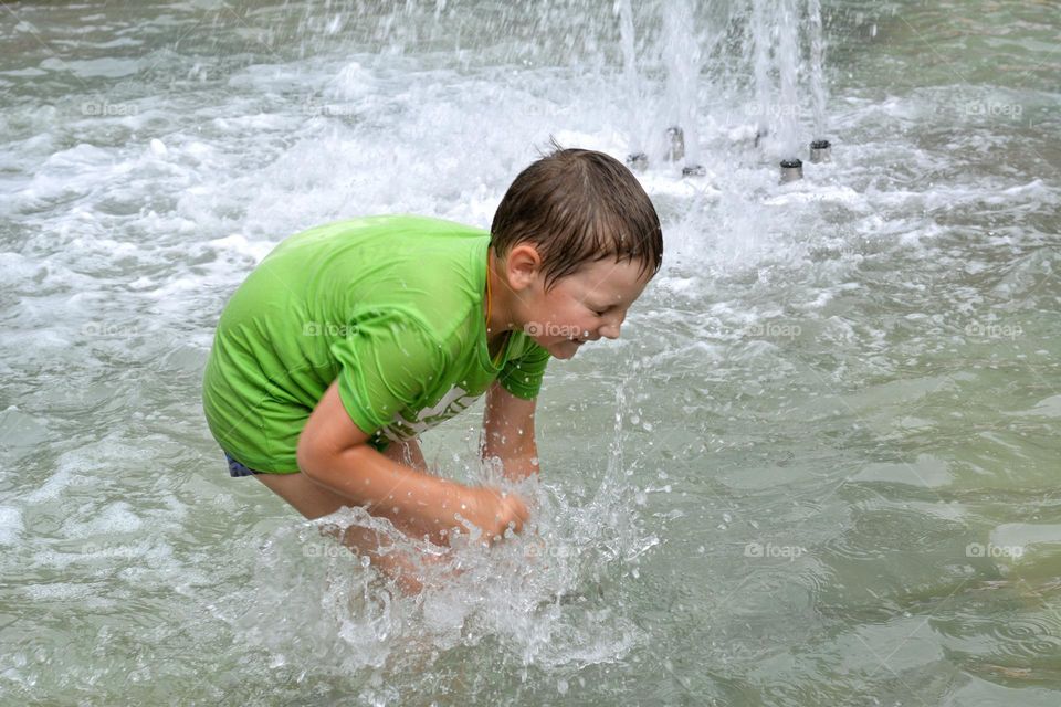 child in water fountain summer heat