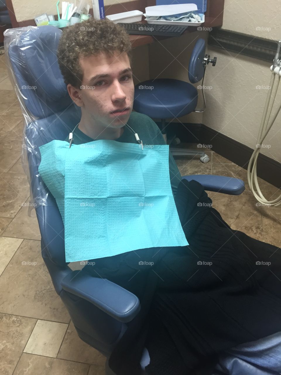 Teenage boy in dentist chair afraid 