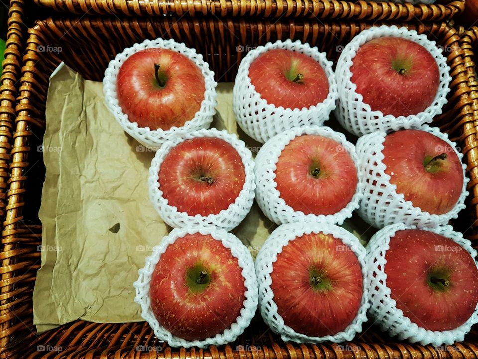 Group of big red apples displayed in basket