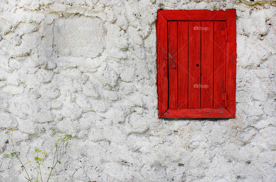 Red woden window on a white wall