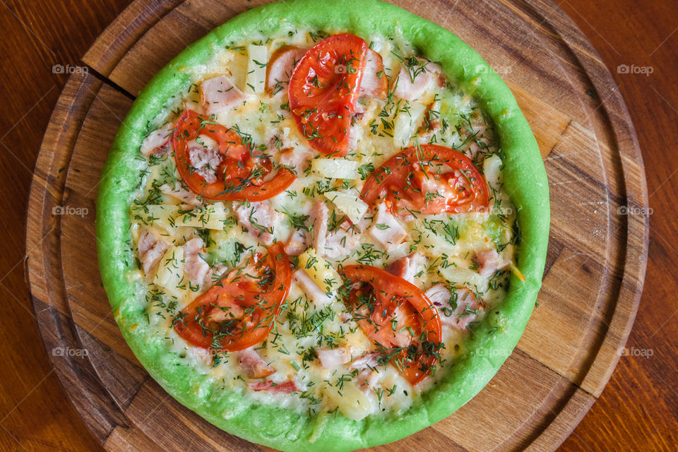 green pizza with tomatoes